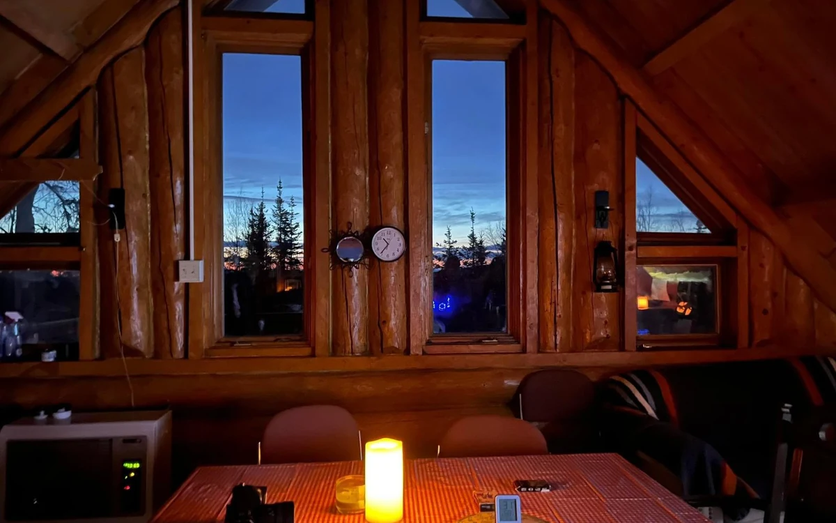 The inside of a warm cabin near Fairbanks with a lamp lit